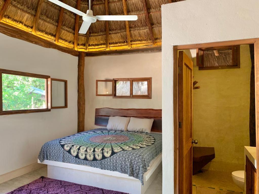 Private palapa room interior at Tulum Nueve — natural wood, stone and soft linen