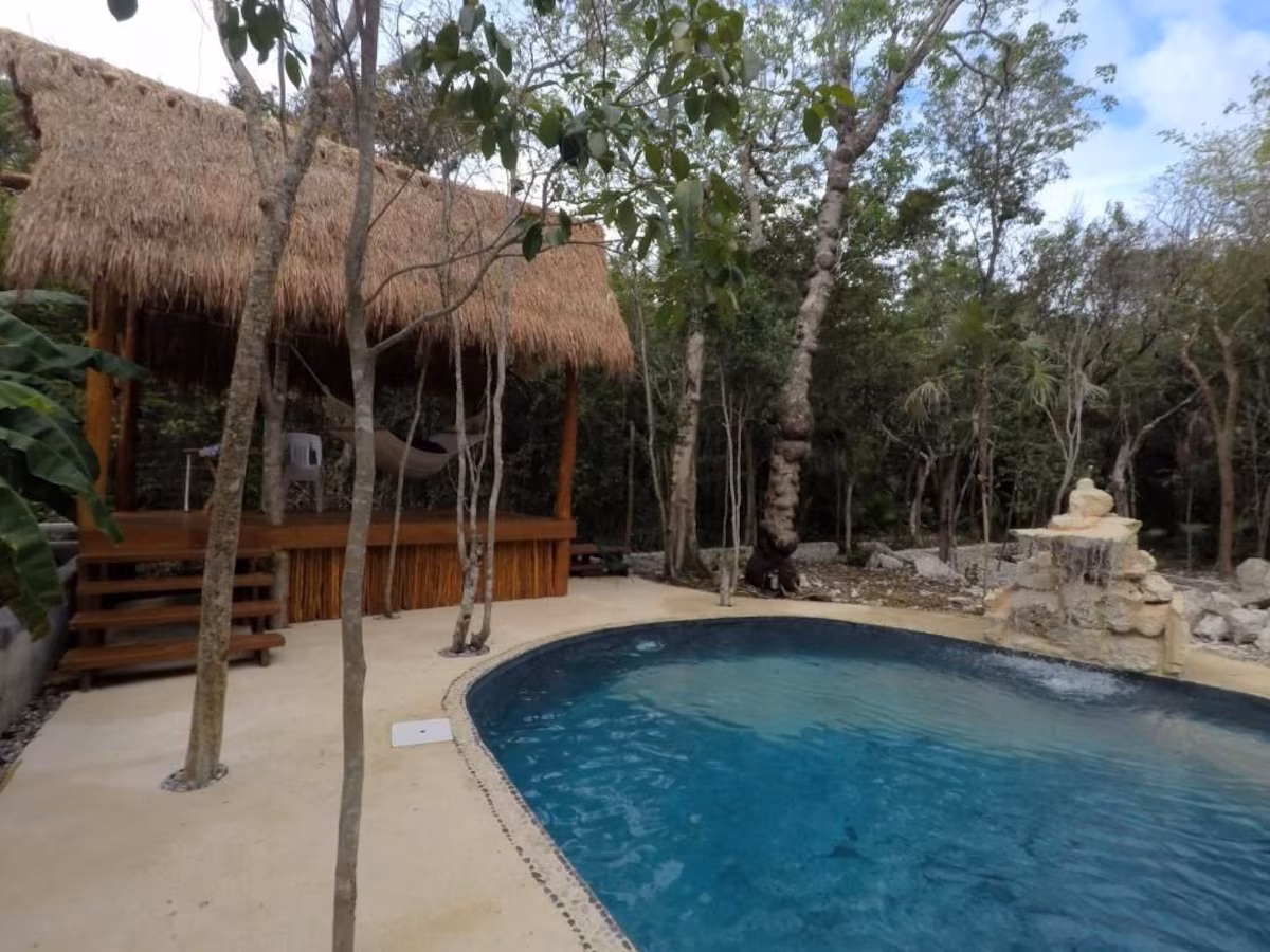 Real swimming pool and outdoor relaxation area at Tulum Nueve retreat venue in Tulum, Mexico.