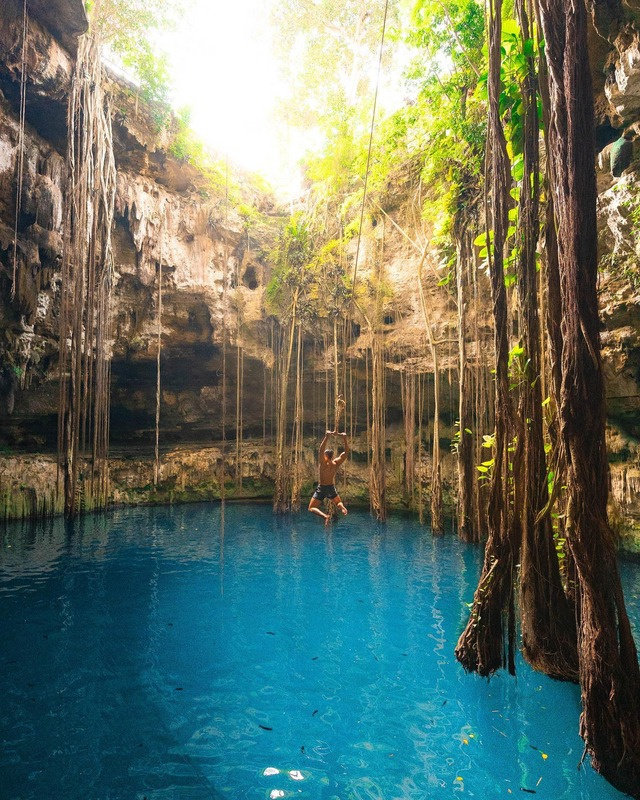 The private cenote at DORA Jungle Retreat, still turquoise water beneath the jungle canopy